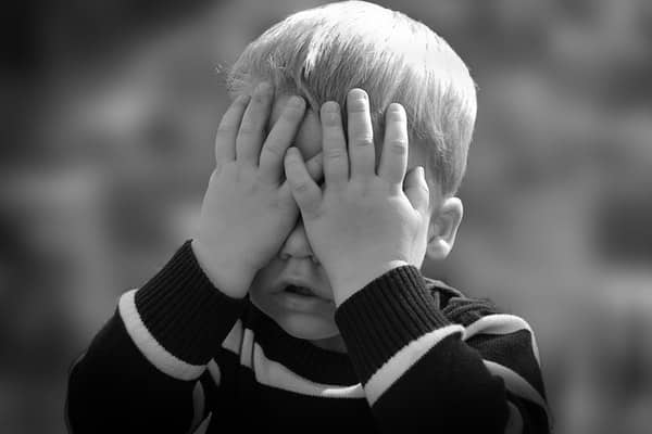 Ways to deal with and prevent back talk: in the image, Boy in Black and White Sweater Covering His Face With His Tow Hand